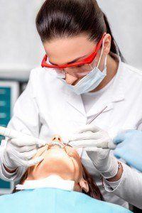 Dentist making professional teeth cleaning to fight periodontal disease