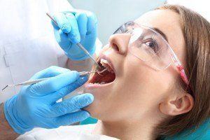 Dentist performing teeth and gum exam