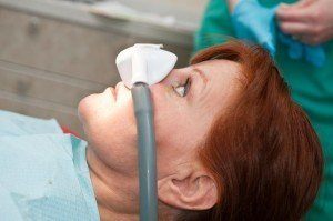 Lady wearing sedation nosepiece, getting laughing gas as a option for sedation dentistry.